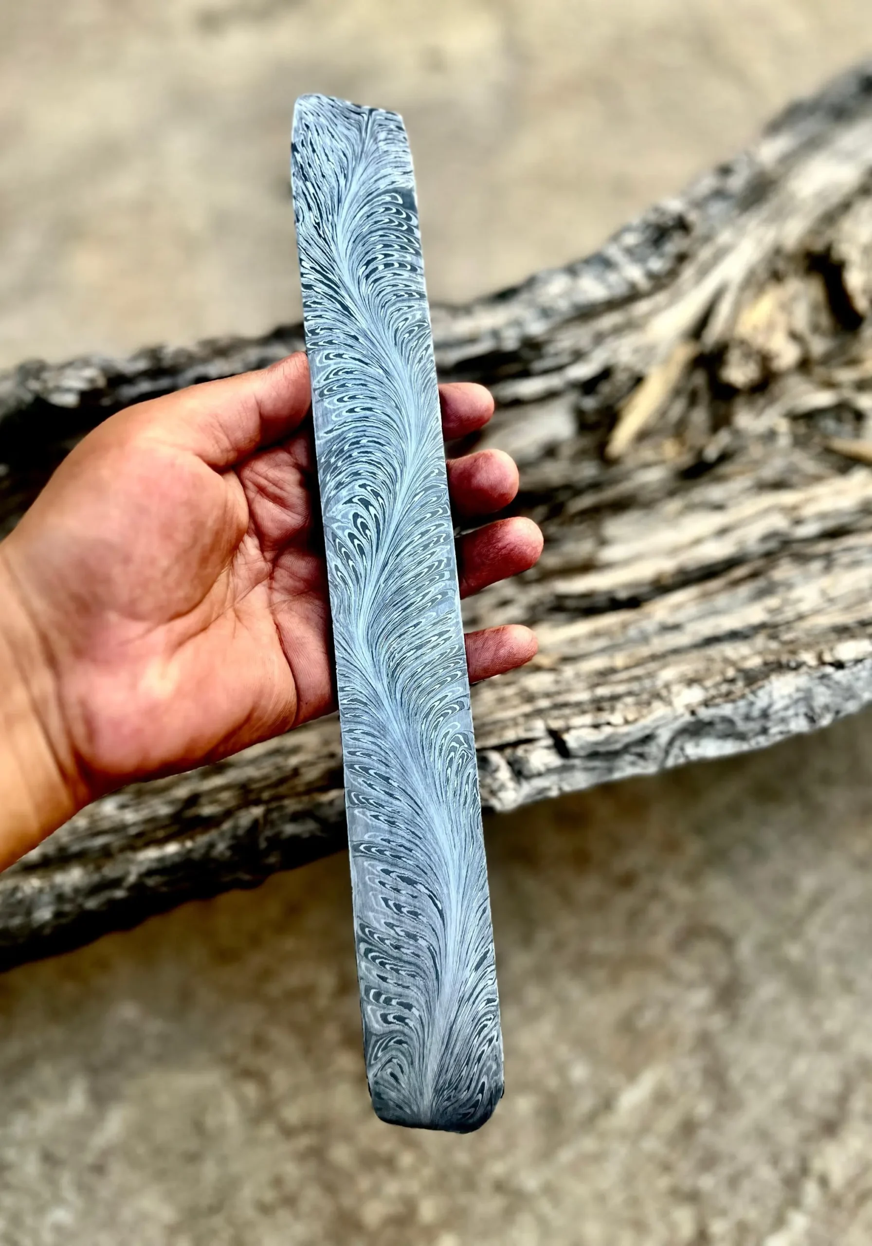 Hand holding Damascus steel billet with River of Fire pattern – 280mm x 50mm x 3.4mm – forging-ready knife billet