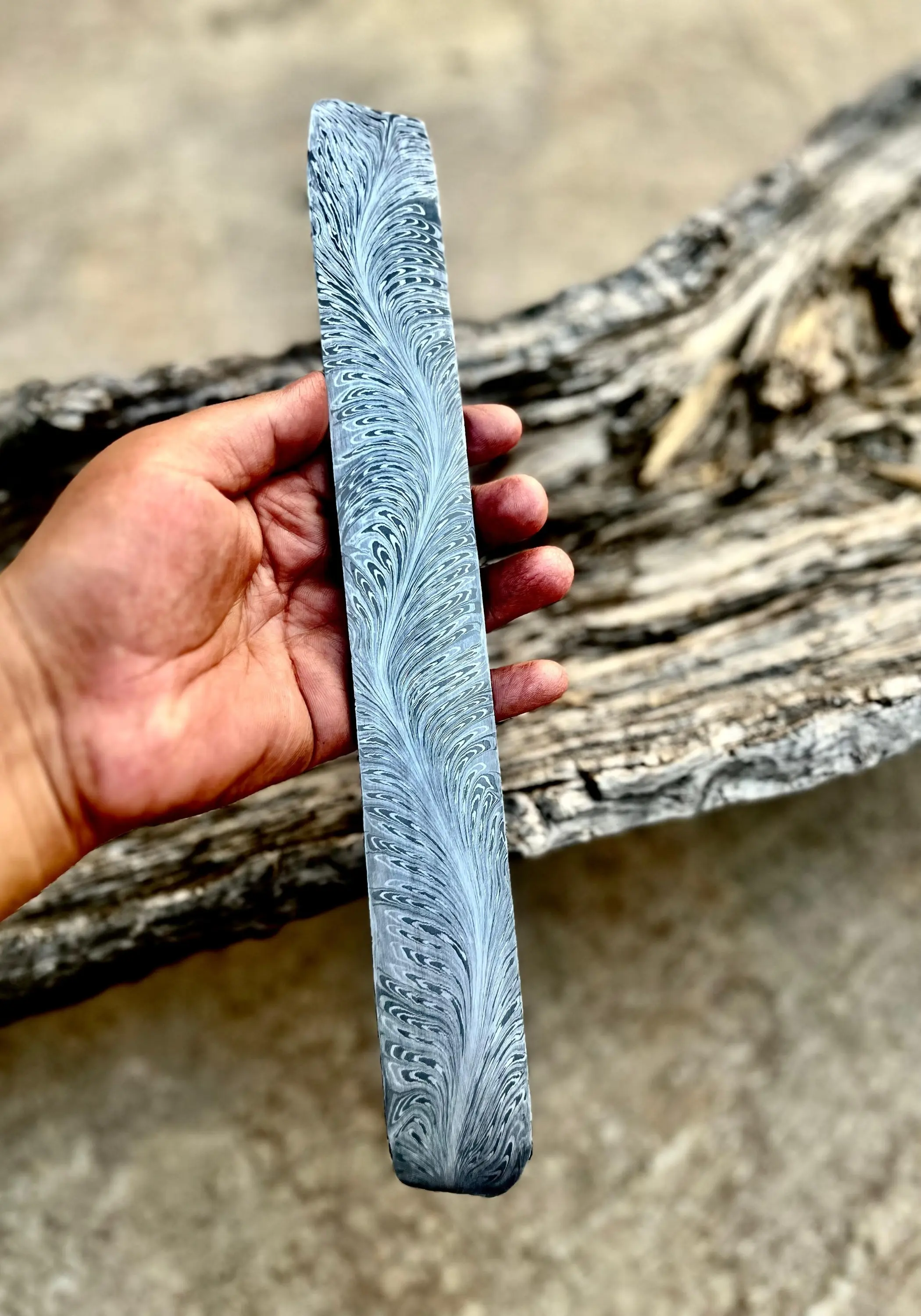 Hand holding Damascus steel billet with River of Fire pattern – 280mm x 50mm x 3.4mm – forging-ready knife billet